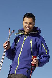 Middle Aged Man On Ski Holiday In Mountains