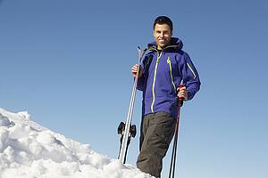 Middle Aged Man On Ski Holiday In Mountains