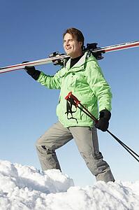 Middle Aged Man On Ski Holiday In Mountains