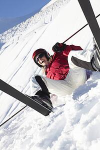 Female Skier Sitting In Snow With After Fall