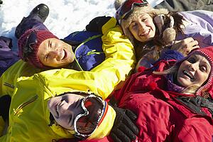 Overhead View Of Teenage Family Lying In Snow On Ski Holiday In Mountains