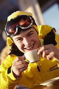 Teenage Boy Enjoying Hot Drink In CafÃ© At Ski Resort