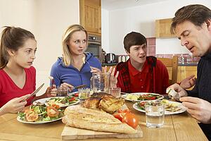 Teenage Family Having Argument Whilst Eating Lunch Together In Kitchen