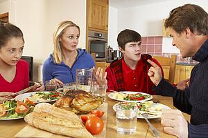 Teenage Family Having Argument Whilst Eating Lunch Together In Kitchen