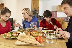 Teenage Family Having Argument Whilst Eating Lunch Together In Kitchen