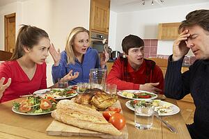 Teenage Family Having Argument Whilst Eating Lunch Together In Kitchen