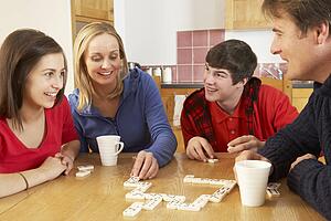 Family Playing Dominoes In Kitchen