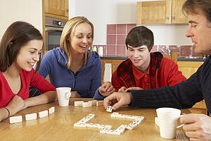 Family Playing Dominoes In Kitchen