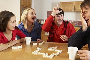Family Playing Dominoes In Kitchen