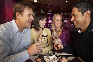 Group Of Friends Enjoying Sushi In Restaurant