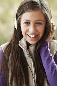 Teenage Girl Wearing Headphones And Listening To Music Wearing Winter Clothes