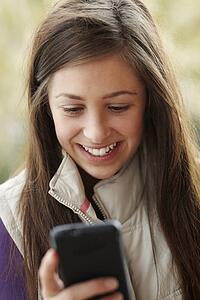 Teenage Girl Texting On Smartphone Wearing Winter Clothes